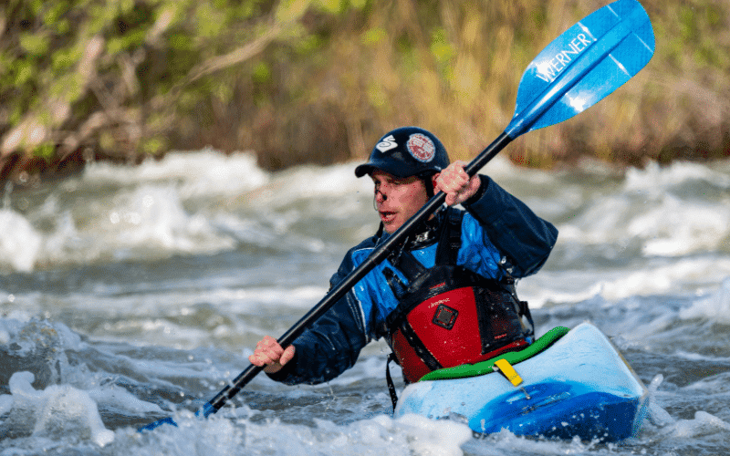 A kayaker swiftly applies first aid to a minor injury, demonstrating proper techniques to prevent and treat injuries in the sport