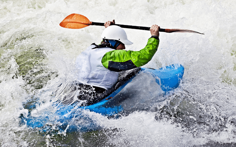 A sea kayaker executes advanced paddling techniques in rough waters